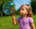 Bambini che giocano insieme con bolle di sapone, stimolando coordinazione e immaginazione in un ambiente educativo.