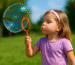 Bambini che giocano insieme con bolle di sapone, stimolando coordinazione e immaginazione in un ambiente educativo.